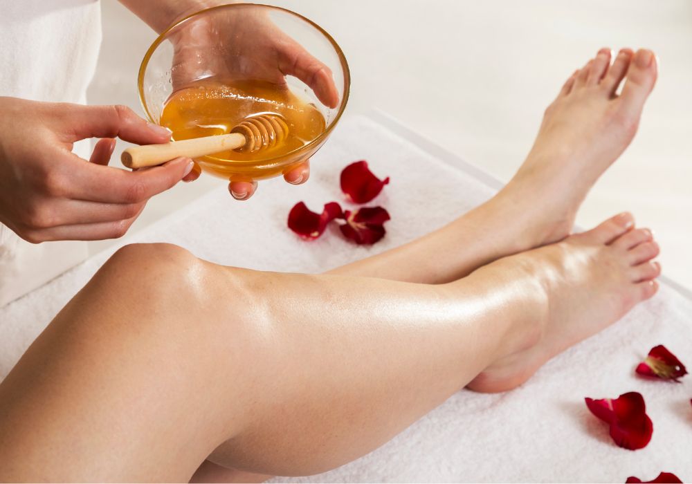 Close-up of a professional leg waxing treatment in a clean spa environment.